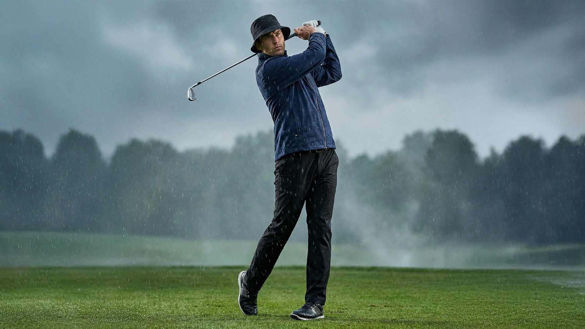 Person playing golf on a rainy day with misty background
