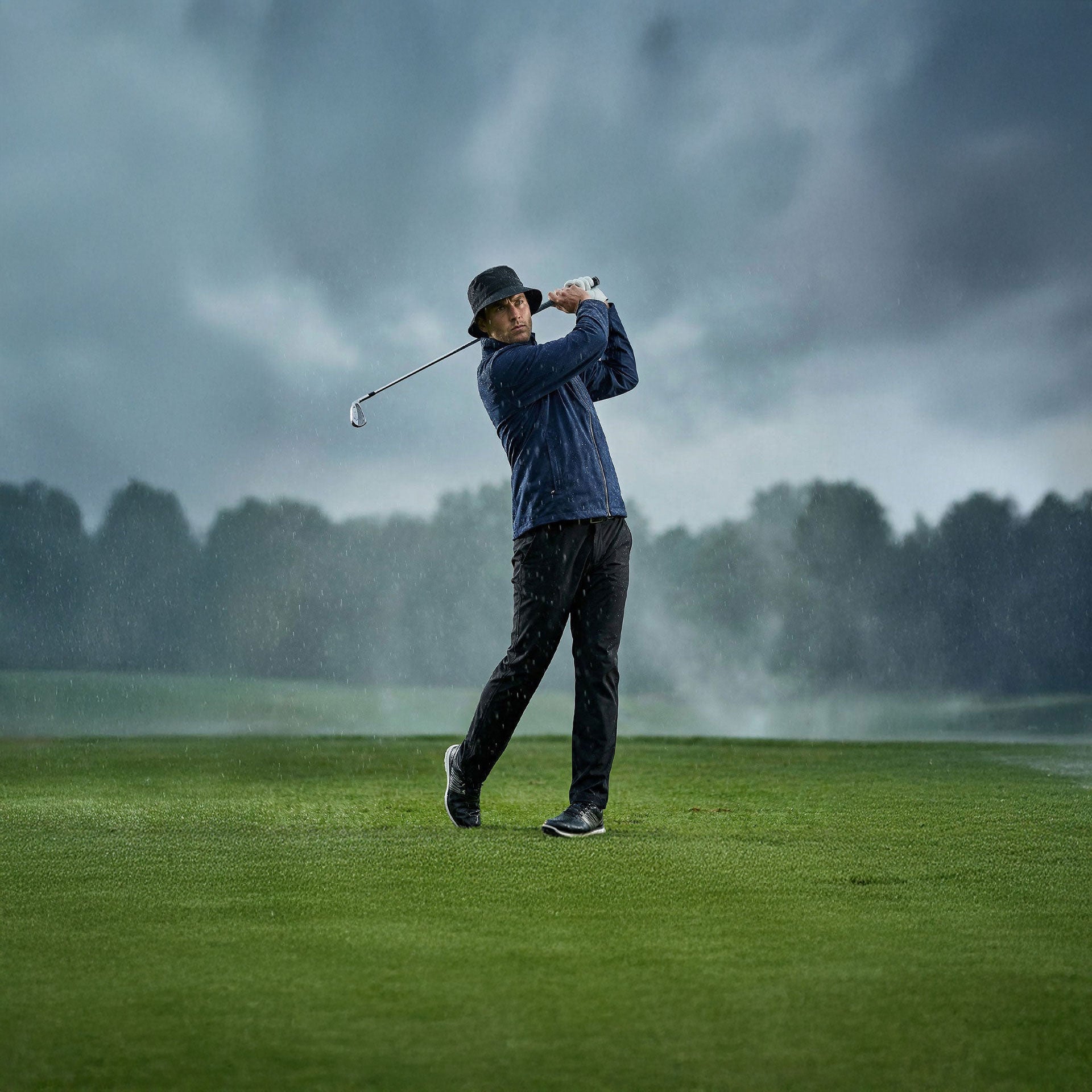 Person playing golf on a rainy day with dark clouds in the background