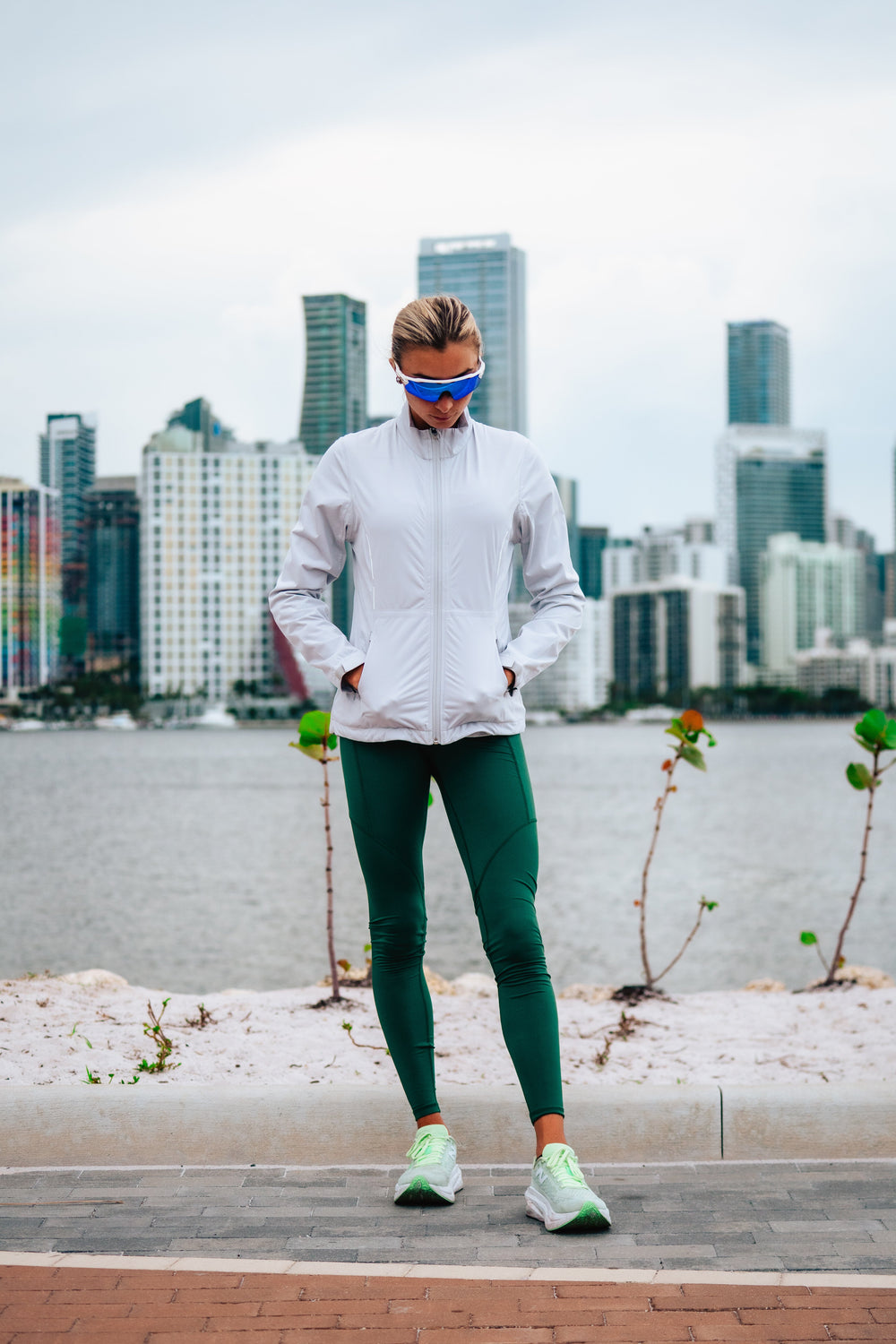 Person in Sunice athletic wear standing on a side walk with city skyline in the background